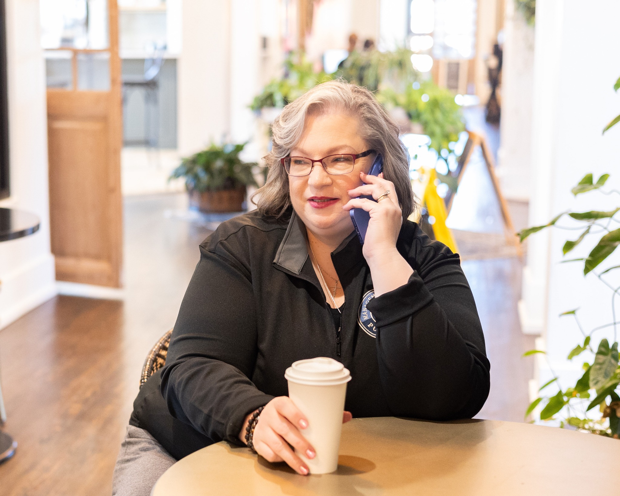 Jennifer Parlier taking a business call in a bright workspace
